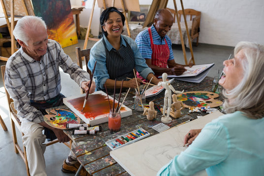 Group of people engaged in an art class, painting and working on various projects.